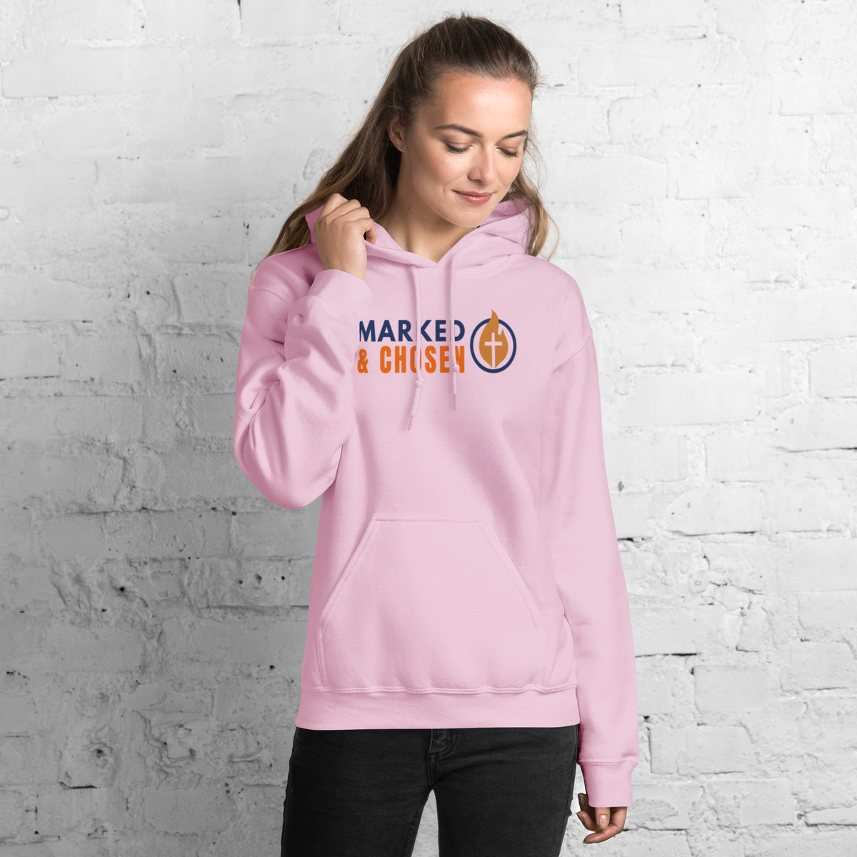 Model wearing Gildan 18500 heavy blend hooded sweatshirt in Light Pink, showing a classic fit and Printed on the front is the Marked & Chosen Logo.
