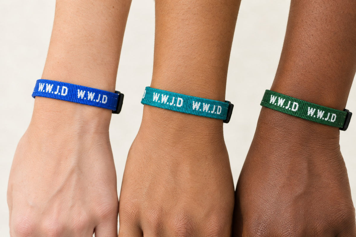 WWJD woven bracelets in royal blue, teal, and forest green worn on three wrists
